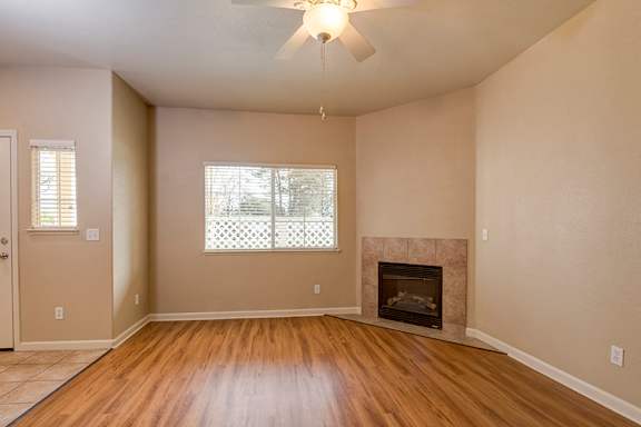 A room with a fireplace and a ceiling fan at LINCOLN GARDENS APARTMENTS, California