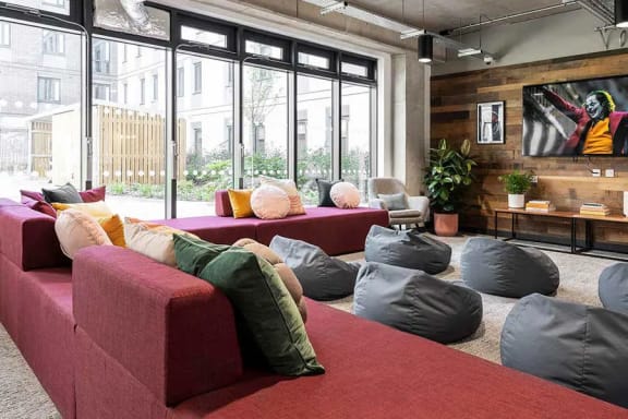 a living room with couches and pillows in front of large windows