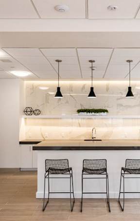 A kitchen with a bar area and four chairs.