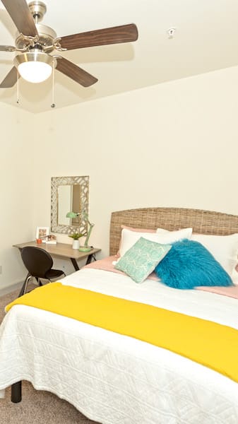 a bedroom with a bed and a ceiling fan at Midtown Sam Houston Apartments, Huntsville, TX, 77340