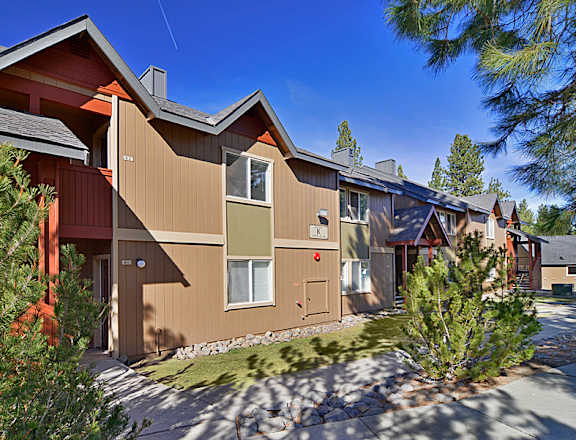 an image of the exterior of a building with trees in the foreground and a blue sky in