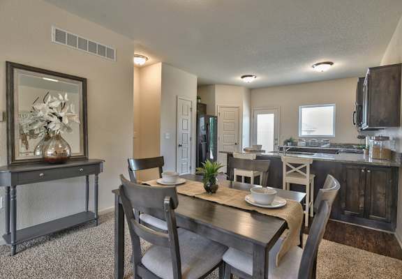 A dining room with a wooden table and chairs.