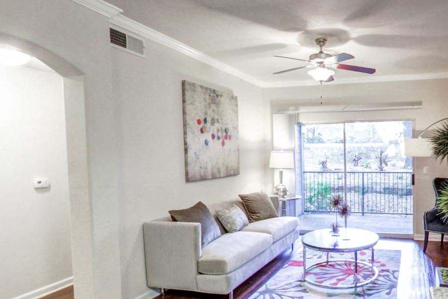 Nolina Flats living room with hardwood-style flooring and patio access - Austin, TX