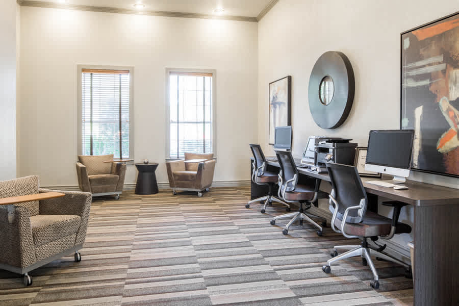 Nolina Flats business center with computers and desk seating - Austin, TX