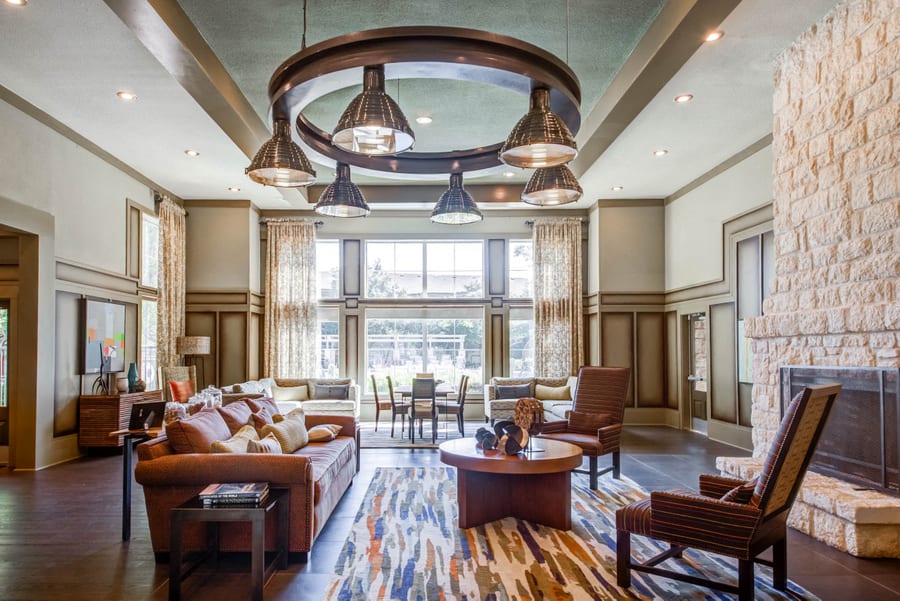 Abelia Flats community lounge with seating and fireplace - Austin, TX