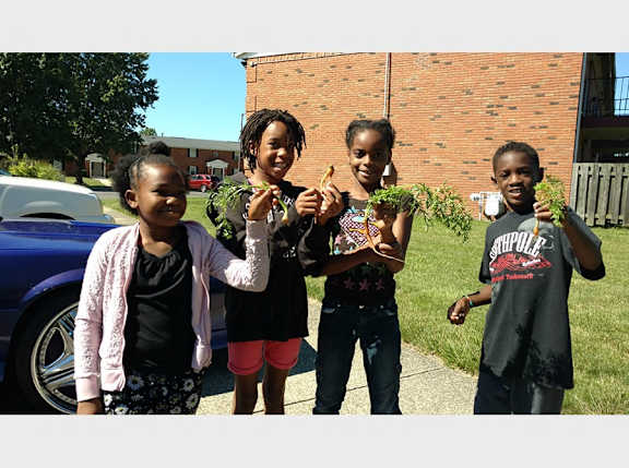 a group of children holding plants in their hands