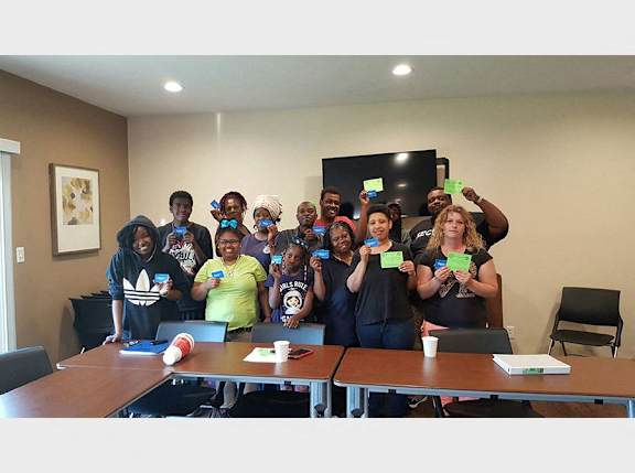 A group of people holding up green cards in a room.
