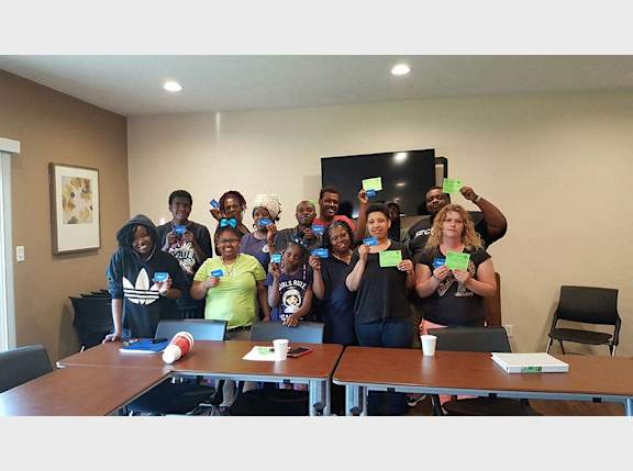 A group of people holding up green cards in a room.