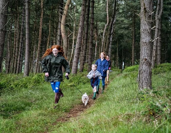 a group of people walking in the woods with a dog at UnionView Apartments, Dartford, KENT