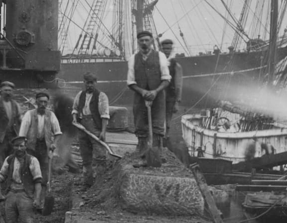 a group of men standing on the deck of a ship