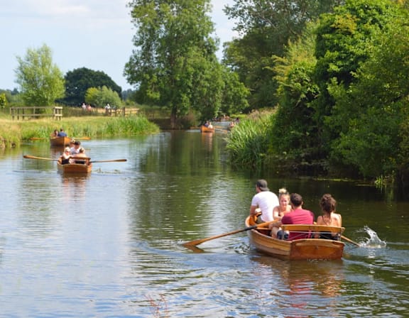 people are rowing boats down a river