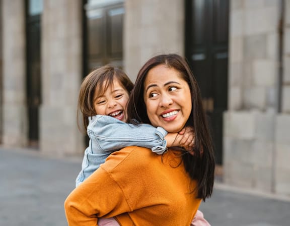 a mother and daughter smiling and hugging each other