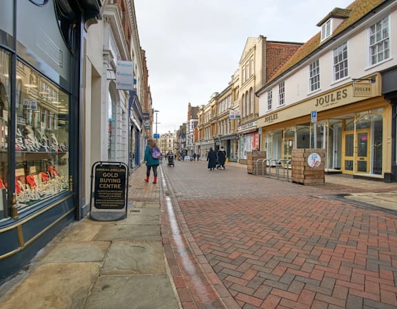 a city street with people walking down a brick street