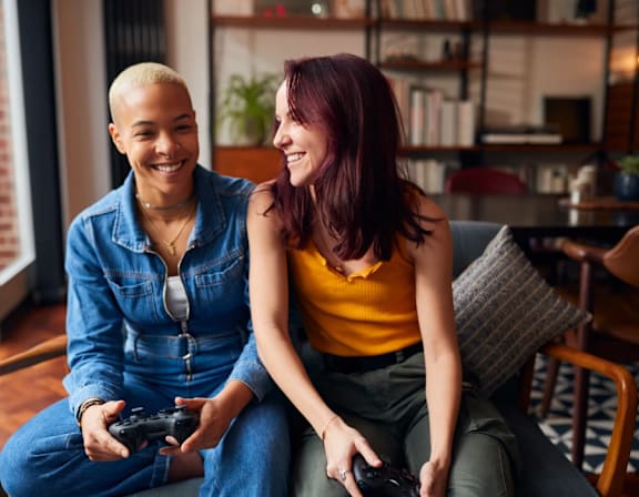 a woman and a man sitting on a couch playing video games