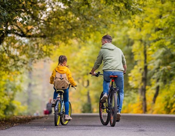 a man and a boy riding bikes down a road at UnionView Apartments, Dartford DA2 6GZ