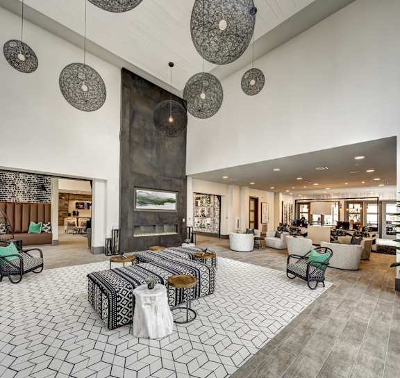 A modern living room with a large fireplace and patterned floor tiles at Arise Riverside Apartments, Austin, TX, 78741