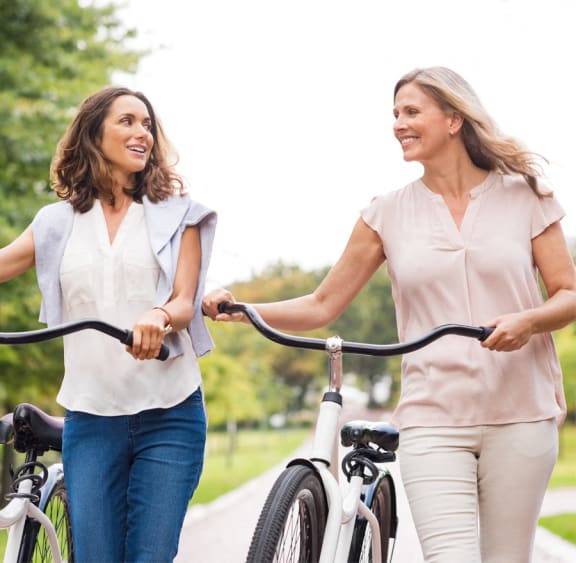 a man and a woman riding bikes in a park