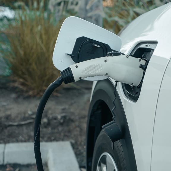 a plug in electric car is plugged into a charging station