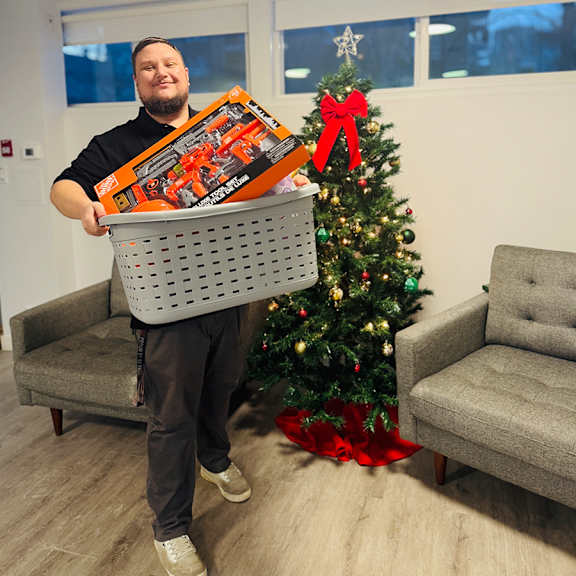 A man holding a box with a toy car on it.