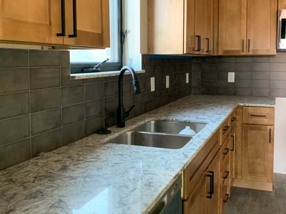 a kitchen warm tan cabinets and a beige countertops