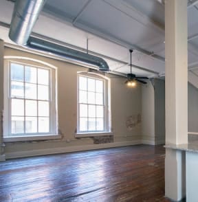 a spacious loft with massive windows, exposed ducts, and hardwood floors at Goodall-Brown Lofts