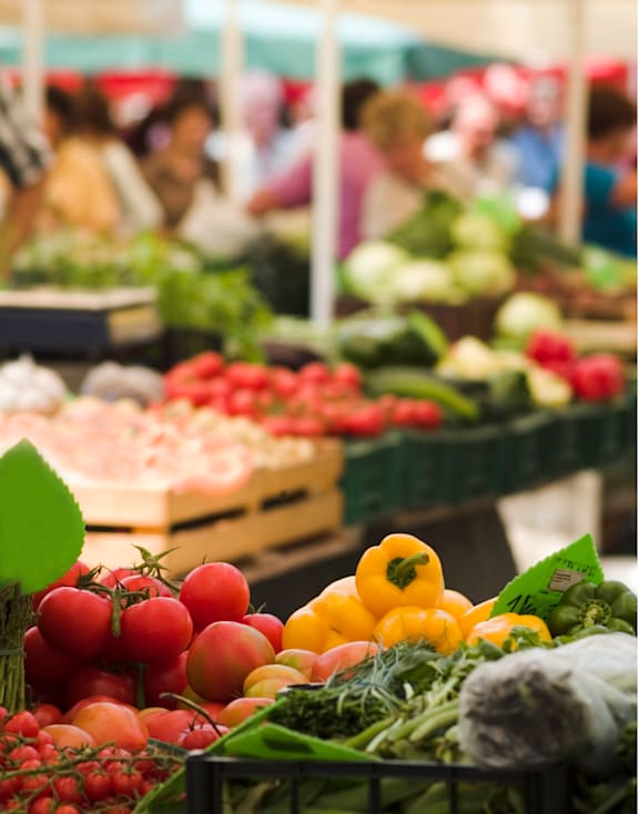 A market scene with a variety of vegetables on display.