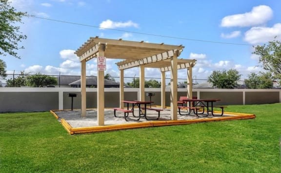 BBQ grills with picnic tables under a gazebo