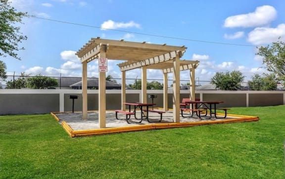 BBQ grills with picnic tables under a gazebo