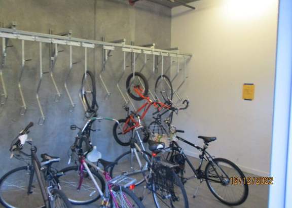 A bike rack with many bikes hanging on it.