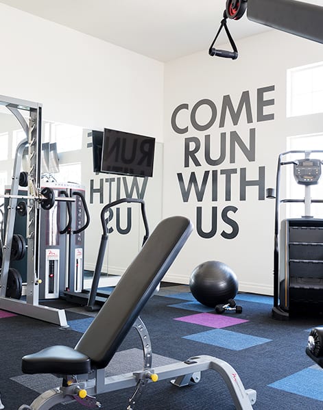 a spacious fitness center with cardio machines and weights