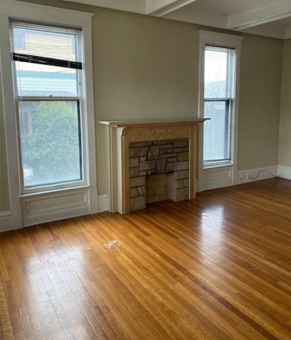 a living room with a fireplace and a wooden floor