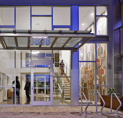 the front of a building with glass doors and a staircase