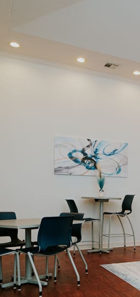 a living room with a blue couch and a table and chairs