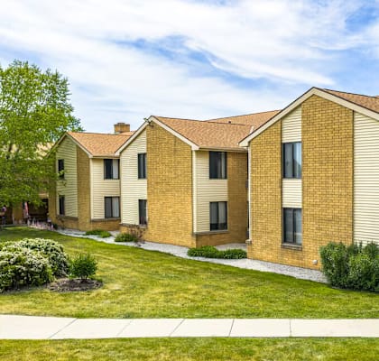 A row of houses with a green lawn in front.