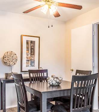 a dining room with a table and chairs and a ceiling fan