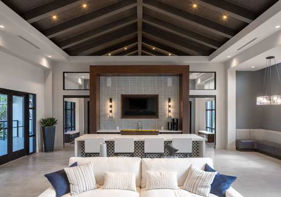 A modern living room with a white couch and a fireplace at Las Palmas Apartments, Fort Myers, FL