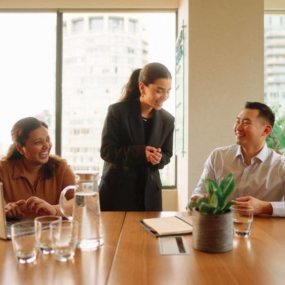 a group of people sitting around a table in a meeting room