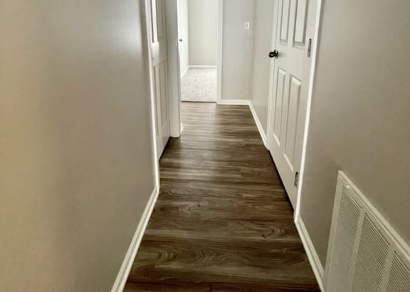 a hallway with wood floors and grey walls