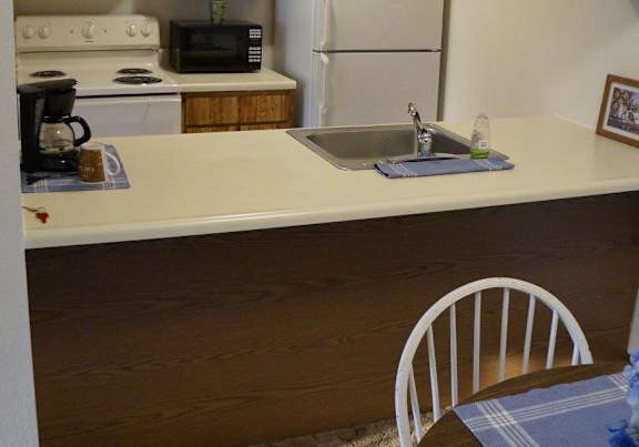 a dining room and kitchen with a table and chairs