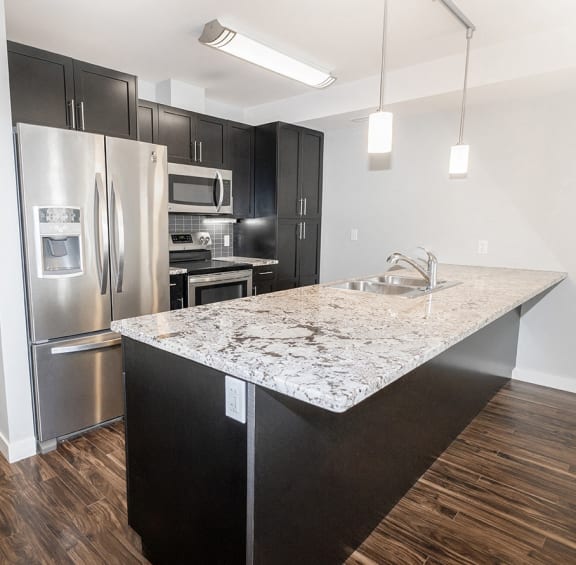 a kitchen with stainless steel appliances and a marble counter top