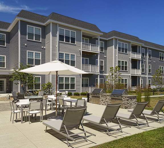 an outdoor patio with tables and chairs at an apartment building