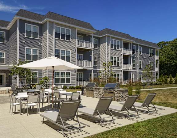 an outdoor patio with tables and chairs at an apartment building