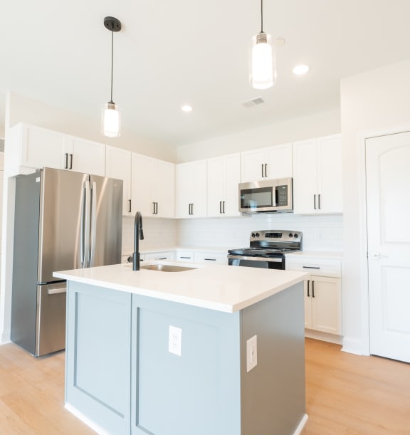 a large kitchen with white cabinets and stainless steel appliances