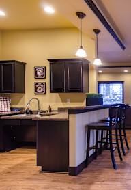 A modern kitchen with a bar area and a television.