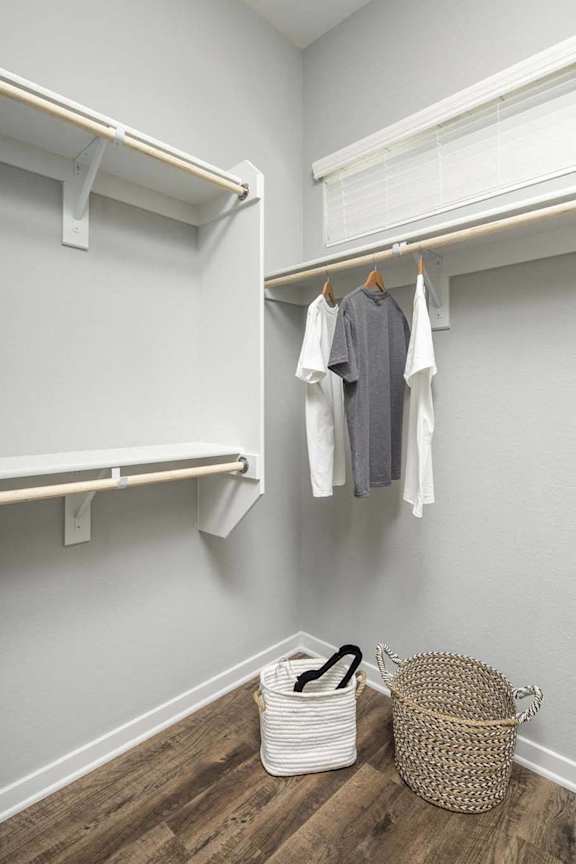 a walk in closet with a basket and clothes hanging at Grandstone at Sunrise, Peoria, AZ, 85383