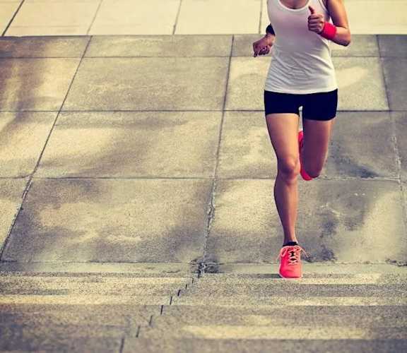 A woman is running on a tiled surface.