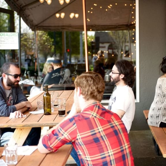 People enjoying drinks in outdoor seating area at Lower Burnside Lofts in Portland, OR
