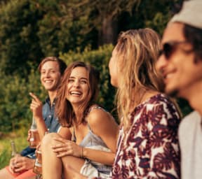 Friends Sitting on Grass Laughing
