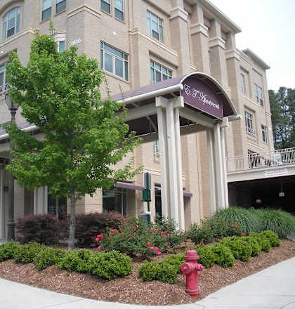 A large building with a red fire hydrant in front of it.