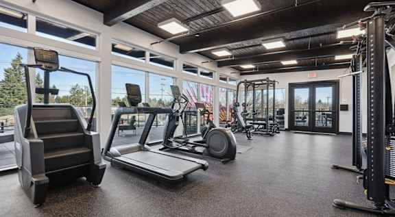 A gym with treadmills, weights, and exercise equipment at AVIVA apartments in Gresham Oregon